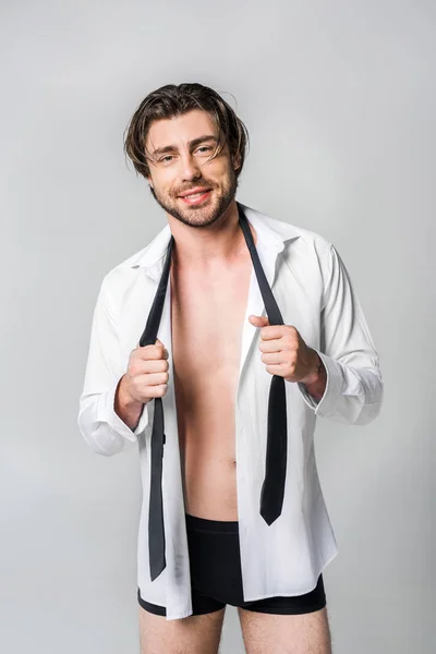 Retrato de sonriente joven con estilo en camisa blanca con corbata negra aislada en gris - foto de stock