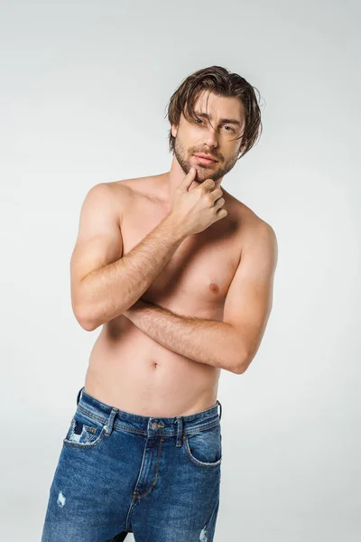 Портрет задумчивого мужчины без рубашки в джинсах, изолированного на сером — стоковое фото
