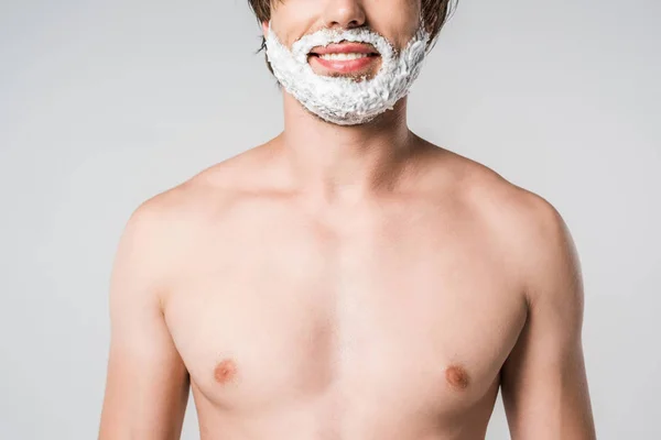 Vista parcial del hombre sin camisa con espuma de afeitar en la cara aislada en gris - foto de stock