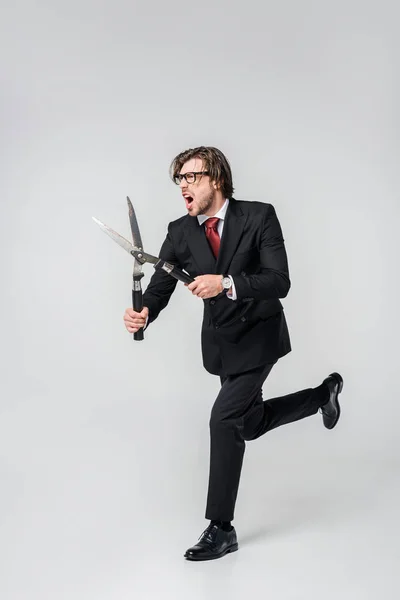 Empresario emocional con clipper sobre fondo gris - foto de stock