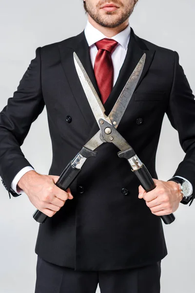Обрізаний знімок бізнесмена в чорному костюмі з затискачем в руках ізольовано на сірому — стокове фото