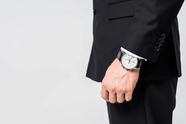 Cropped shot of businessman in black suit with watch on wrist isolated on grey — Stock Photo