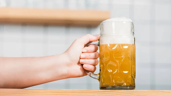 Vue partielle du barman femelle mettant tasse de bière légère avec mousse sur le comptoir de la barre — Photo de stock