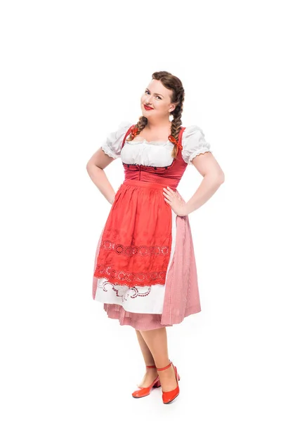 Garçonete oktoberfest sorridente em vestido tradicional bávaro com as mãos na cintura isolada no fundo branco — Fotografia de Stock