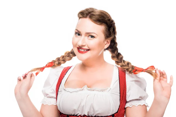 Attractive oktoberfest waitress in traditional german dress showing pigtails isolated on white background — Stock Photo