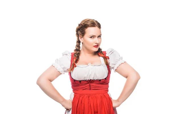 Confiante garçonete oktoberfest em vestido tradicional bávaro de pé com as mãos na cintura isolada no fundo branco — Fotografia de Stock