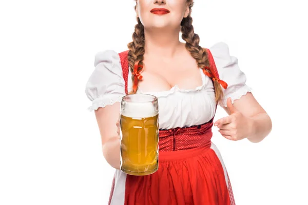 Imagem recortada de garçonete oktoberfest em vestido tradicional bávaro apontando por dedo para caneca de cerveja leve isolada no fundo branco — Fotografia de Stock