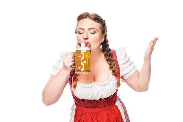 Oktoberfest camarera en vestido bavariano tradicional bebiendo cerveza ligera aislada sobre fondo blanco - foto de stock