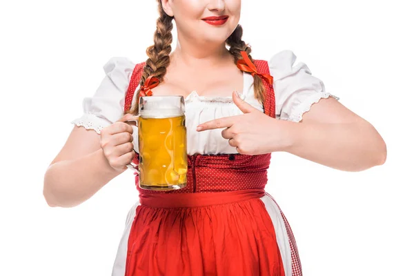Частичный вид на Октоберфест официантки в традиционном баварском платье, указывающей пальцем на кружку светлого пива, выделенного на белом фоне — стоковое фото
