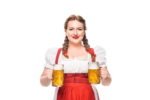 Lächelnde Oktoberfestkellnerin in traditioneller deutscher Tracht mit zwei Bechern hellem Bier auf weißem Hintergrund — Stockfoto