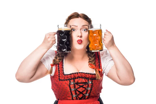 Garçonete oktoberfest em vestido tradicional bávaro segurando canecas com cerveja clara e escura isolada no fundo branco — Fotografia de Stock