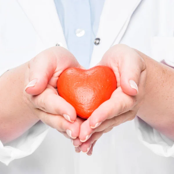 Vista parcial de la doctora en bata blanca mostrando el símbolo del corazón - foto de stock
