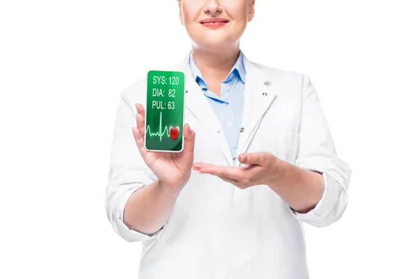 Teilansicht der Ärztin, die auf Smartphone mit Pulsmesser auf weißem Hintergrund zeigt — Stockfoto