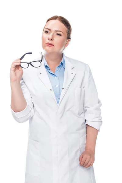 Médecin féminin réfléchi tenant des lunettes isolées sur fond blanc — Photo de stock