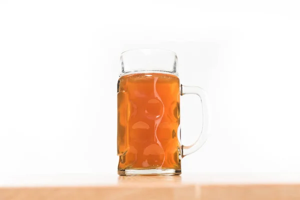 Vista de cerca de la cerveza en taza sobre mesa de madera sobre fondo blanco - foto de stock