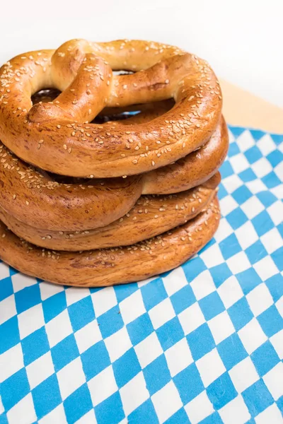 Vista de cerca de sabrosos pretzels en la mesa con mantel sobre fondo blanco - foto de stock