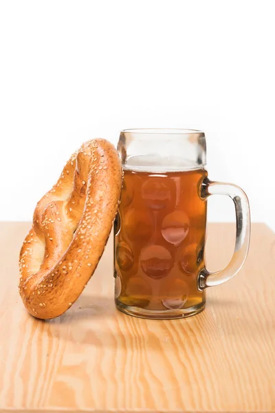 Fuoco selettivo di birra con pretzel su tavolo di legno su sfondo bianco — Foto stock