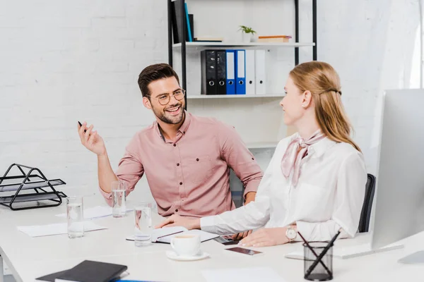 Gente de negocios feliz charlando en el lugar de trabajo en la oficina moderna - foto de stock