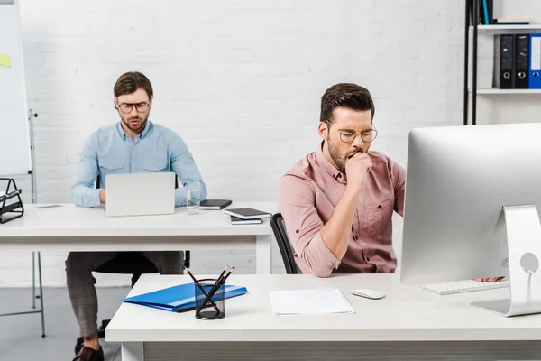 Uomini d'affari concentrati che lavorano con i computer presso l'ufficio moderno — Foto stock