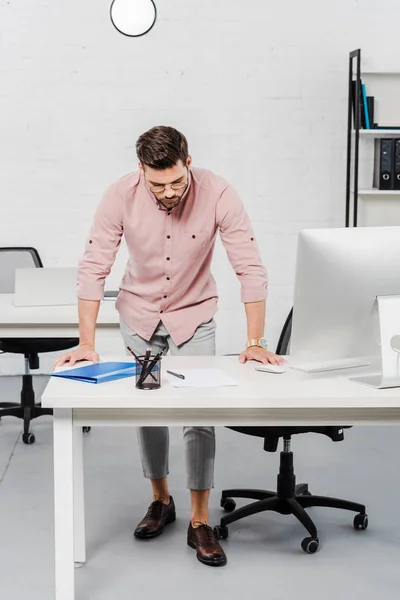 Nachdenklicher junger Geschäftsmann liest Dokumente in modernem Büro — Stockfoto