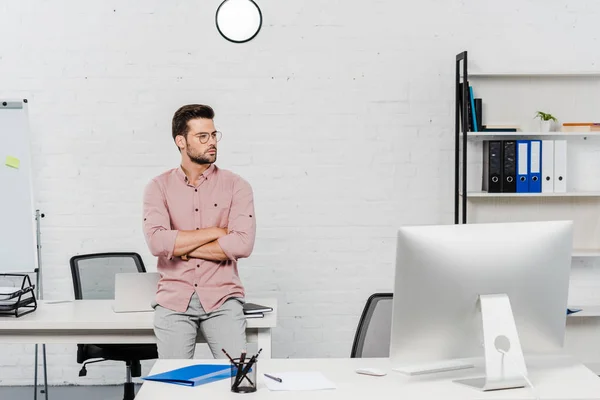 Beau jeune homme d'affaires penché de retour sur le lieu de travail au bureau moderne — Photo de stock