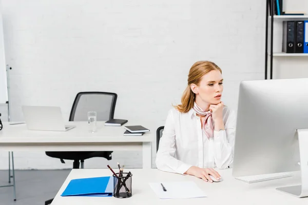 Jeune femme d'affaires concentrée travaillant avec l'ordinateur au bureau moderne — Photo de stock