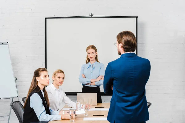 Visão traseira do chefe conversando com os gerentes durante reunião no escritório moderno — Fotografia de Stock