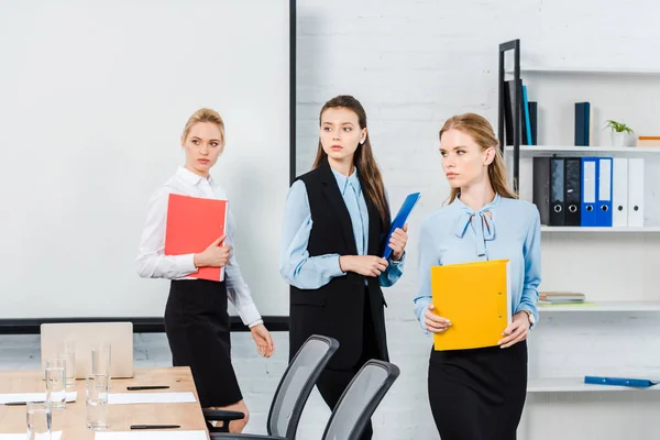 Successful young businesswomen with folders of documents at modern office — Stock Photo