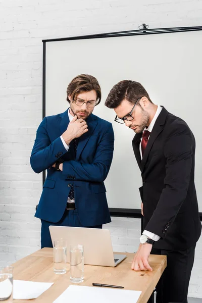 Businessmen working with laptop together at conference room — Stock Photo