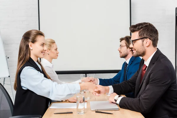 Duas equipes de empresários apertando as mãos durante a reunião no escritório moderno — Fotografia de Stock