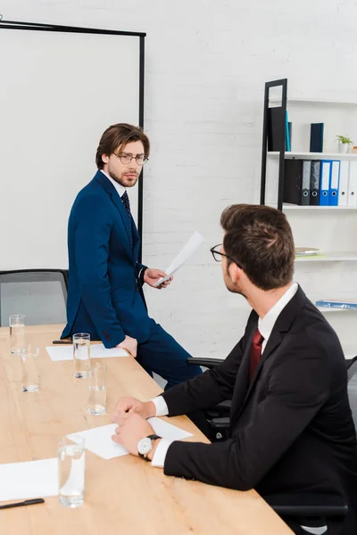 Guapos hombres de negocios exitosos trabajando juntos en la oficina moderna - foto de stock