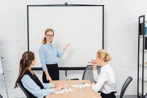 Giovani imprenditrici di successo che ascoltano la presentazione in ufficio moderno — Foto stock