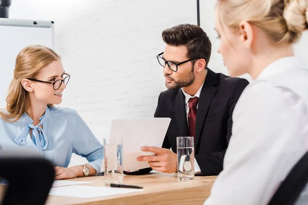 Equipo de socios comerciales conversando en una oficina moderna - foto de stock