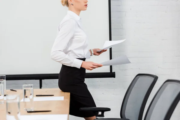 Обрезанный снимок молодой предпринимательницы, читающей документы в конференц-зале — стоковое фото