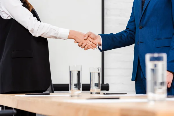 Cropped shot of business colleagues shaking hands at modern office — Stock Photo