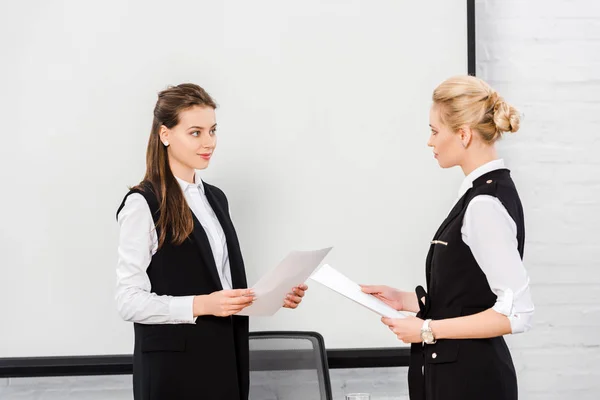 Confident young businesswomen with documents at modern office — Stock Photo