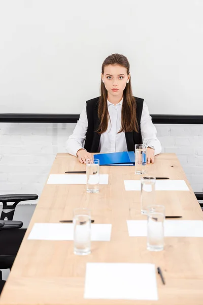 Beautiful young businesswoman sitting at table in conference hall at modern office — Stock Photo