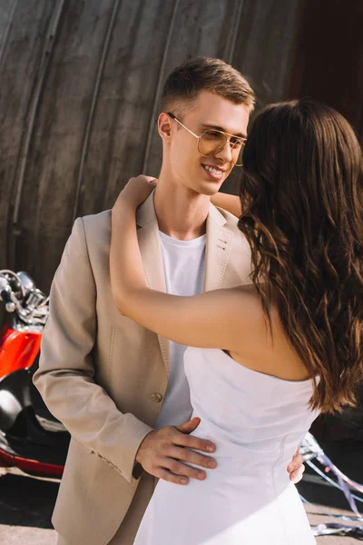 Happy wedding couple embracing in city with scooter — Stock Photo