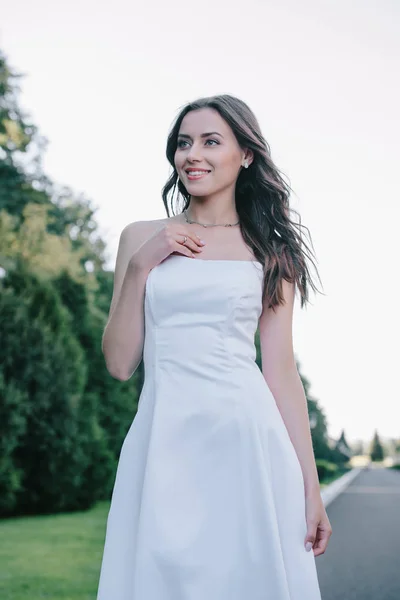 Счастливая красивая невеста позирует в традиционном белом свадебном платье — стоковое фото