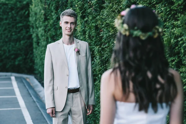 Foyer sélectif de sourire beau marié regardant jeune mariée — Photo de stock