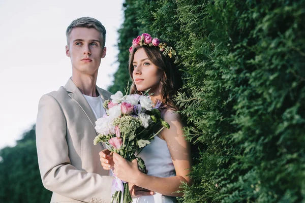 Belo casal de casamento elegante com buquê floral — Fotografia de Stock