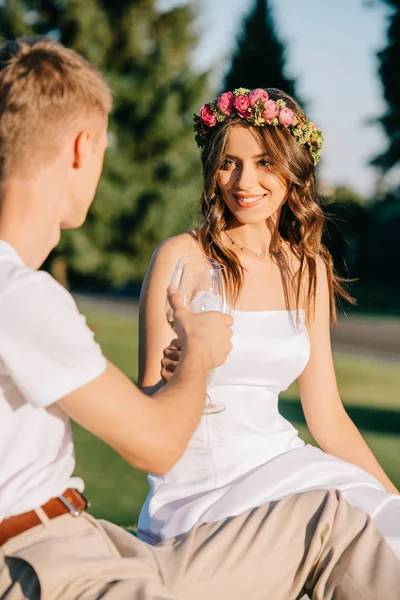 Hermosa boda pareja tintineo con copas de vino en el picnic - foto de stock