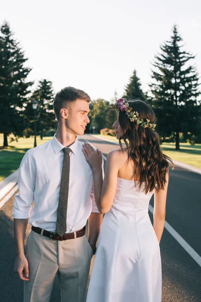 Belle tendre jeune mariée et marié regardant l'autre dans le parc — Photo de stock