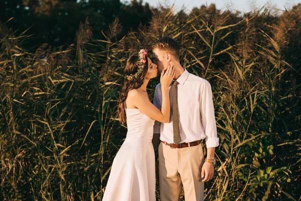 Hermosa elegante joven romántica boda pareja besándose en parque - foto de stock