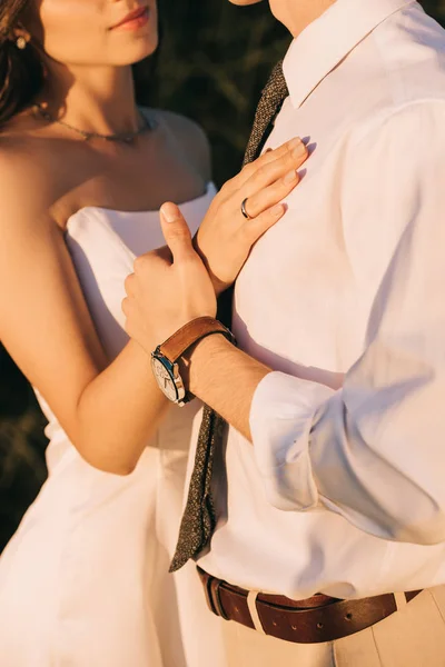 Tiro recortado de amar jovem casamento casal abraçando e de mãos dadas — Fotografia de Stock