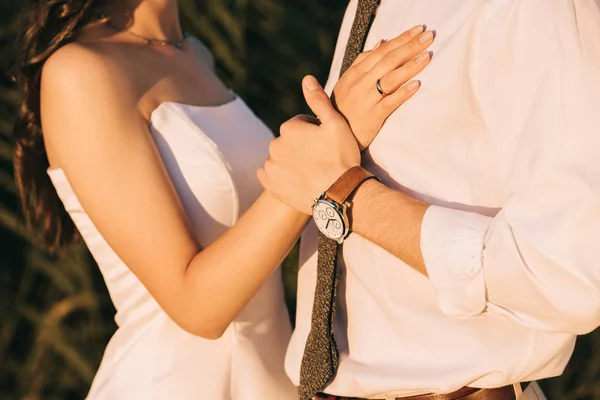 Cropped shot of loving young wedding couple embracing and holding hands — Stock Photo