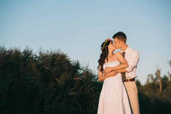 Hermosa elegante joven boda pareja besos en parque - foto de stock