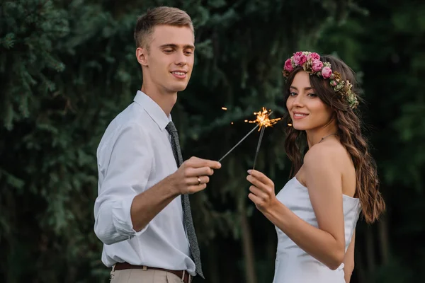 Красива щаслива молода весільна пара тримає блискітки на відкритому повітрі — стокове фото