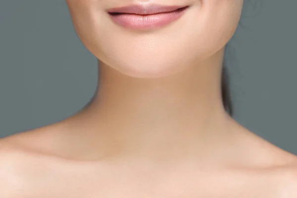 Partial view of smiling woman with bare shoulders isolated on grey — Stock Photo