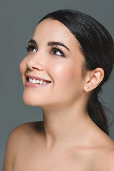 Portrait of attractive smiling woman with white teeth looking away isolated on grey — Stock Photo